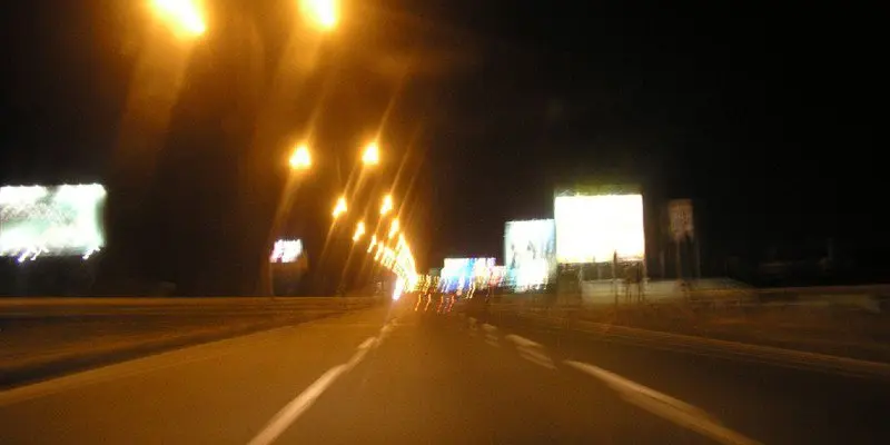 Blurry photo of a highway at night.