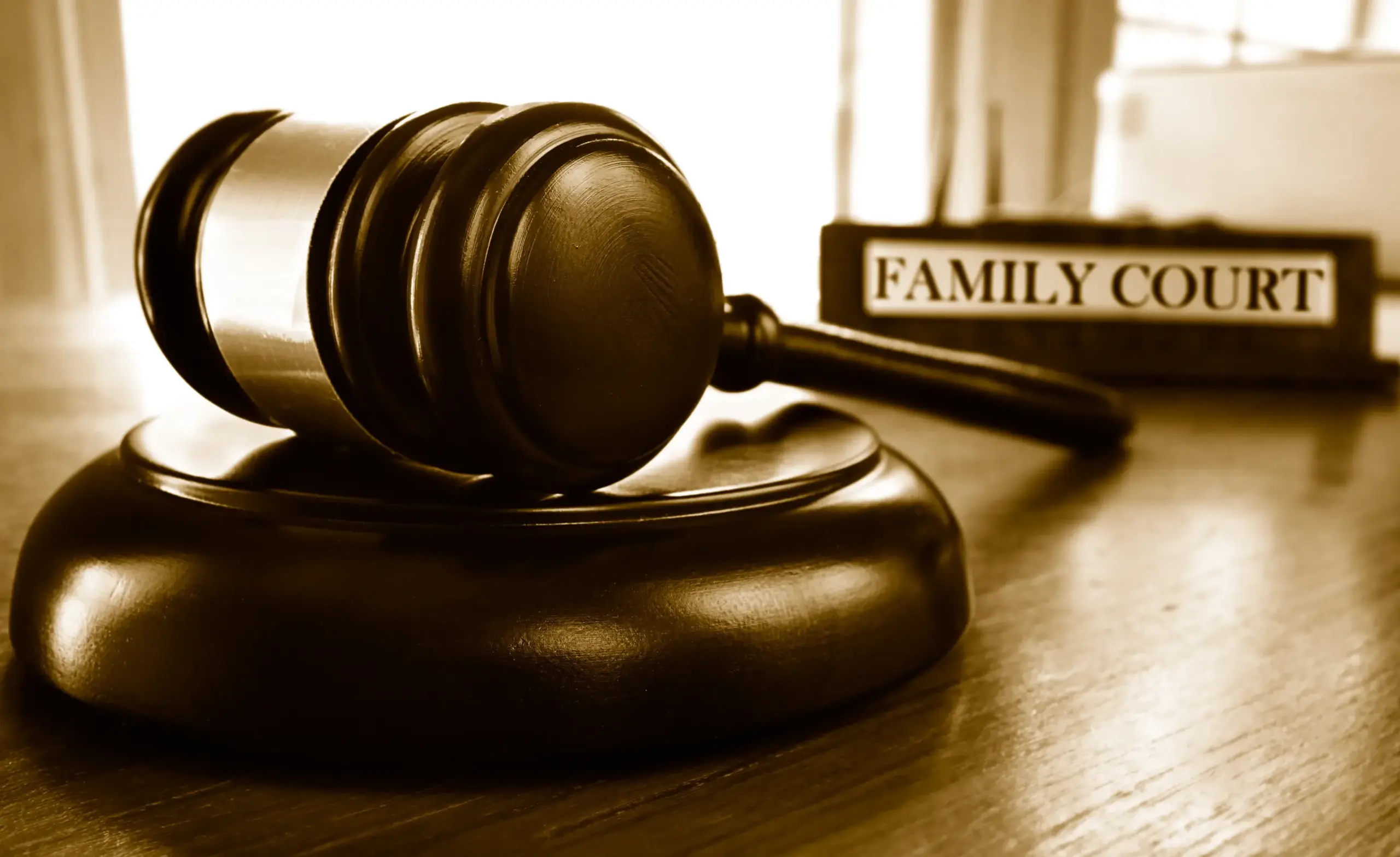 A judge's gavel in front of a desk sign that reads "Family Court".