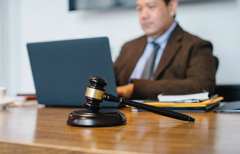 A lawyer working on his laptop next to a gavel