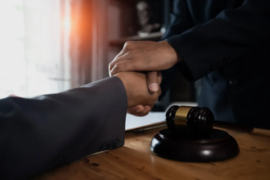 An attorney and client shaking hands up close.