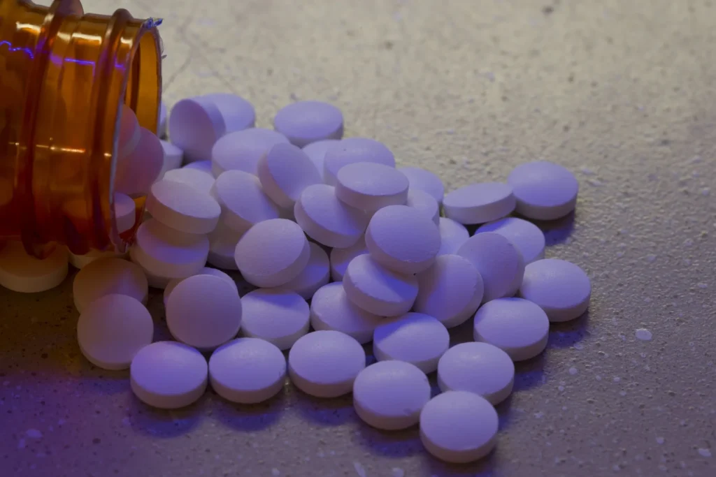 A bottle of pills spilled on a counter.