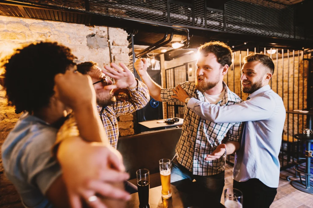 A group of men fighting in a bar.