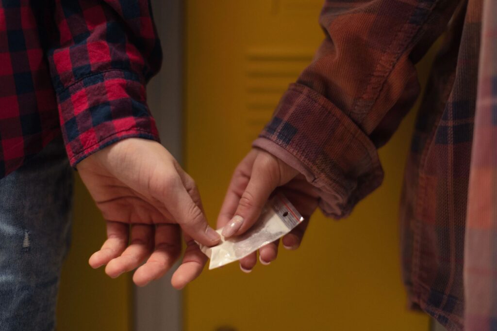 Someone handing off drugs to someone else.
