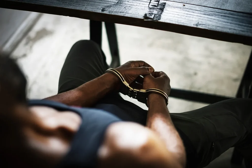 A man in handcuffs sitting at a table.