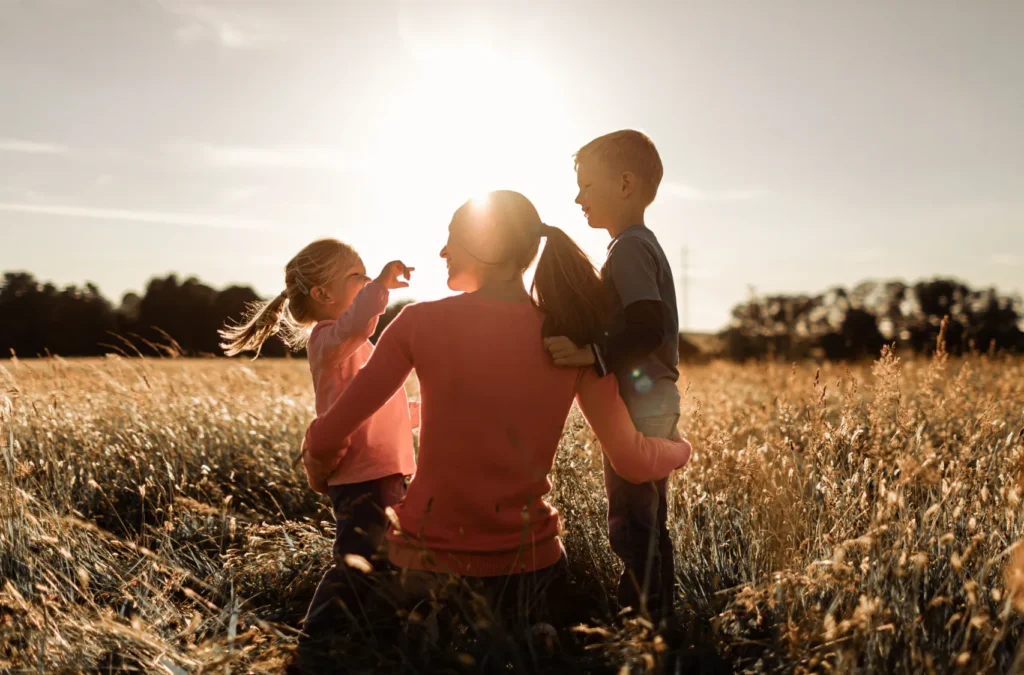 A mother with her two kids in a field.