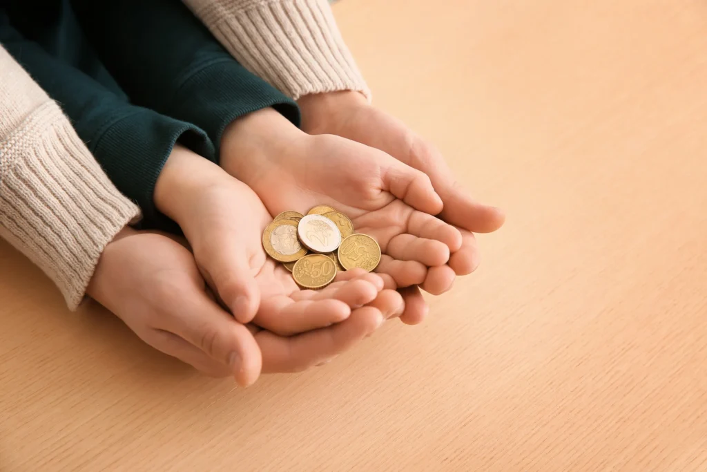A mom and child holding a pile of coins.