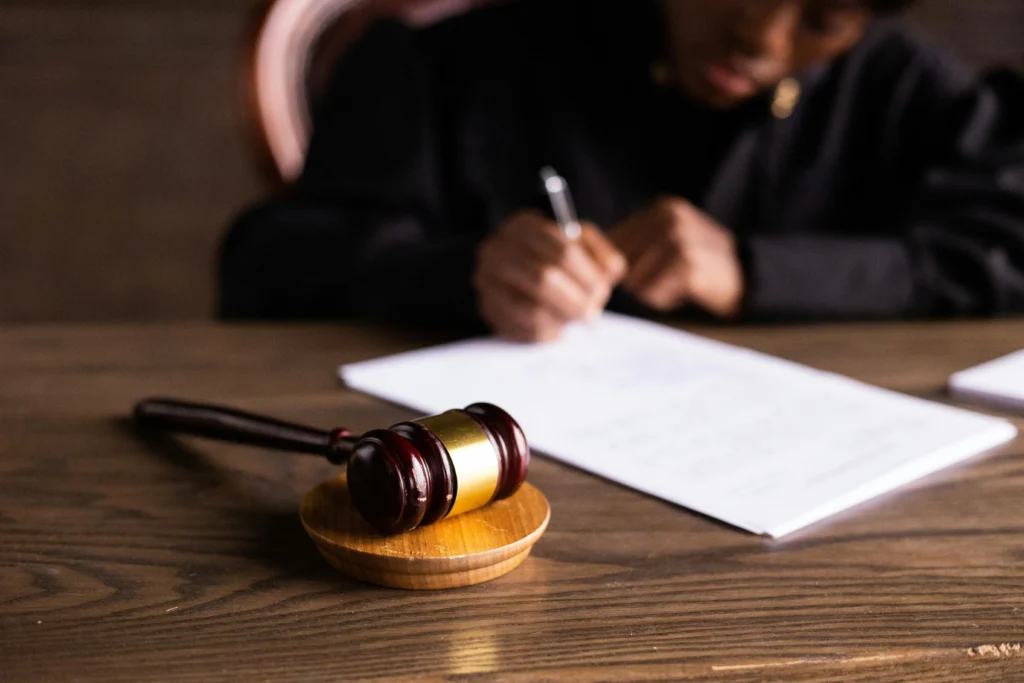 judge writing at desk with gavel
